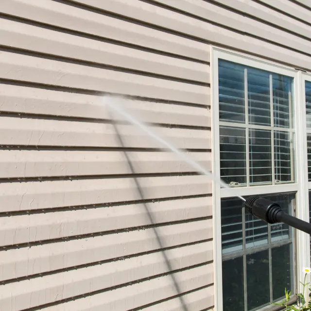 Pressure washing service cleaning exterior surfaces before a painting project.