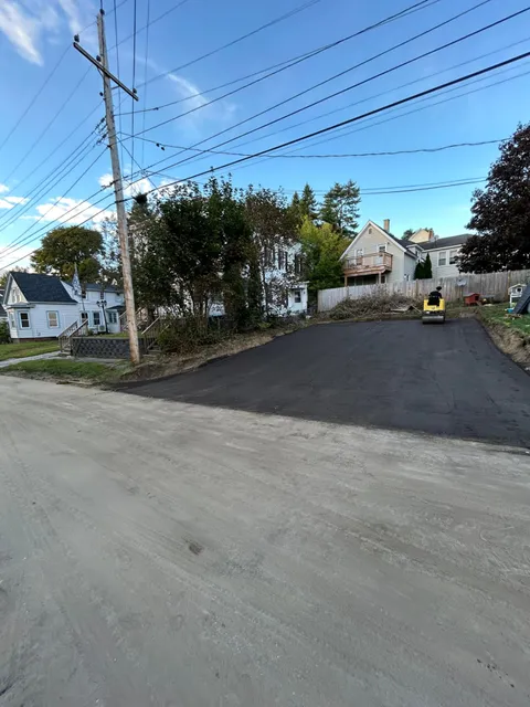 Newly paved driveway with roller finishing compaction