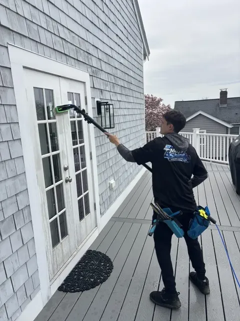 Mass Shine crew cleaning French door glass with water-fed pole on residential home South Shore MA