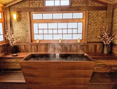 Japanese-inspired indoor spa with mahogany decking and teak soaking tub