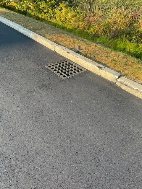 Asphalt repair around a storm drain in southern Maine