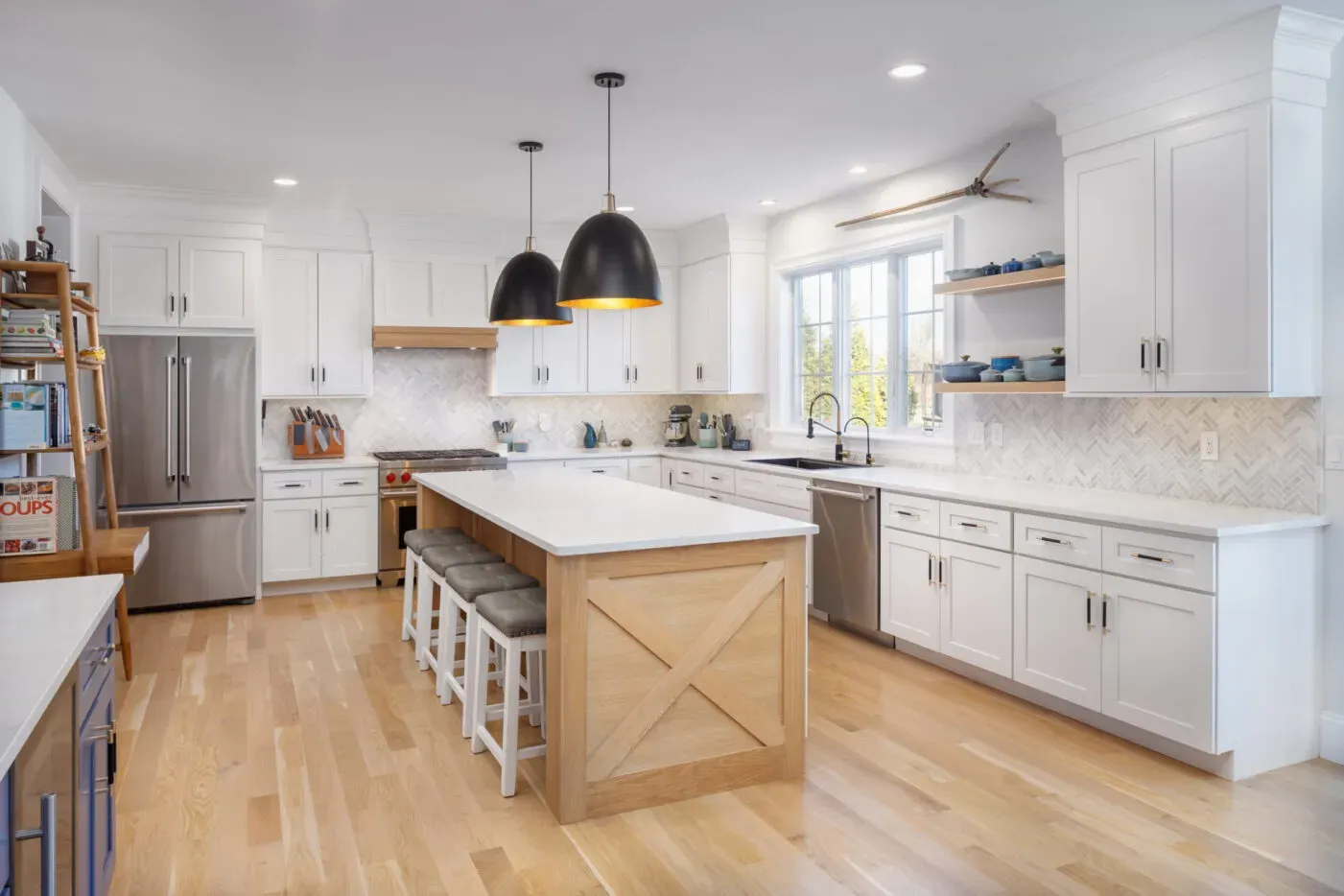 Remodeled kitchen with white cabinetry, island seating and hardwood floors in a Natick, Massachusetts home