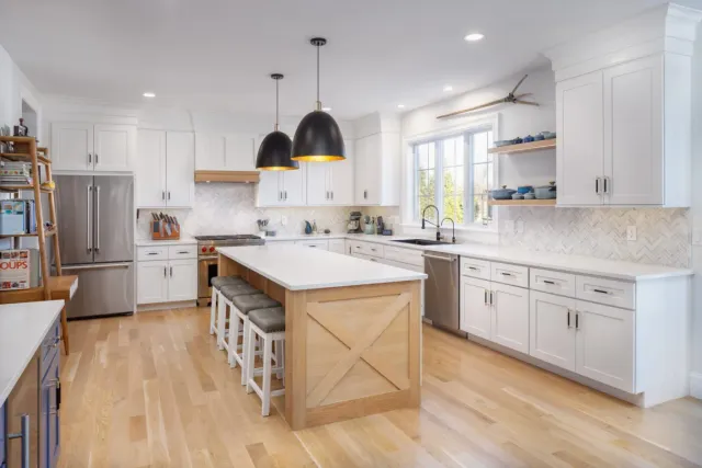 Remodeled kitchen with white cabinetry, island seating and hardwood floors in a Natick, Massachusetts home