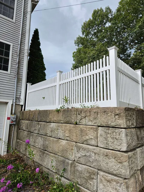 White vinyl picket fence installed by Olympic Fence Company, enhancing curb appeal in a North Shore Massachusetts home.