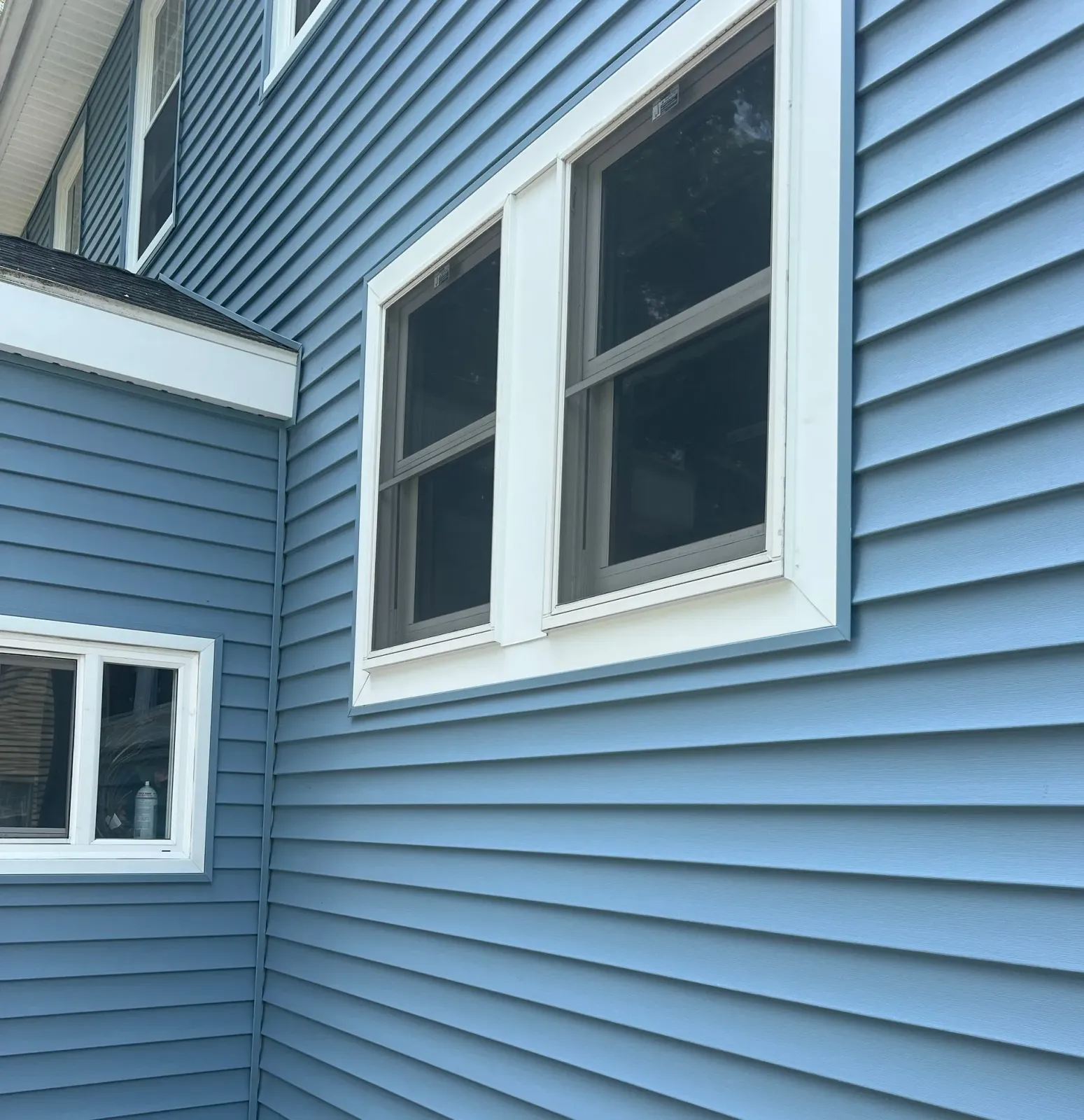 Blue siding with white trim and windows on a house.