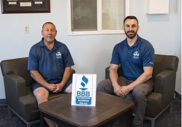 Eastland owners Gregg and Tom Miller sitting in back of a BBB sign