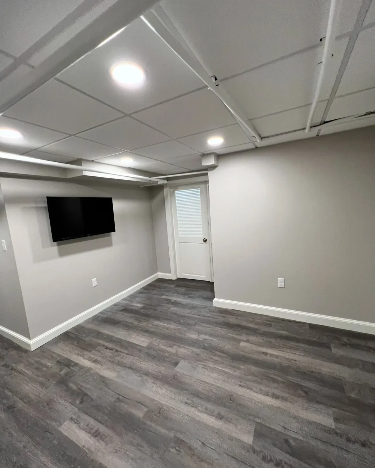 Transformed a previously underused basement into a functional and inviting space. We installed soffits for easier maintenance and to maximize ceiling height, giving the room a more open feel. 

The laundry area was reorganized with hidden machinery f