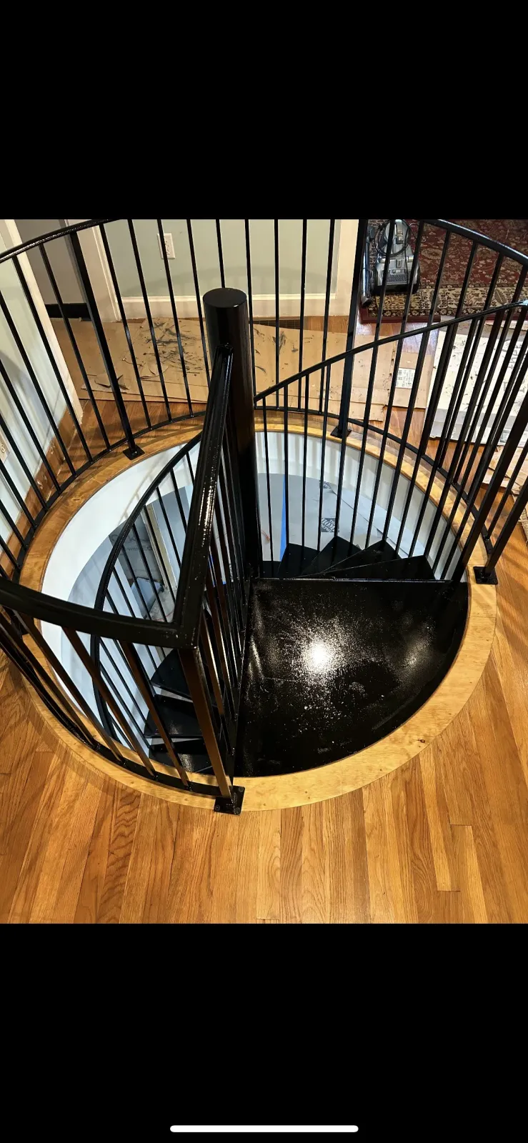 A spiral staircase with a wrought iron railing in a house.