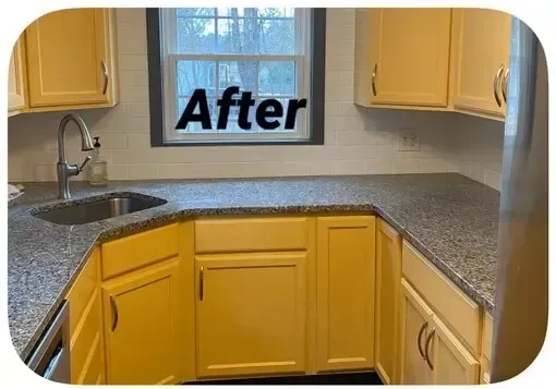 After photo of a kitchen with yellow cabinets, speckled countertops, and a window above the sink