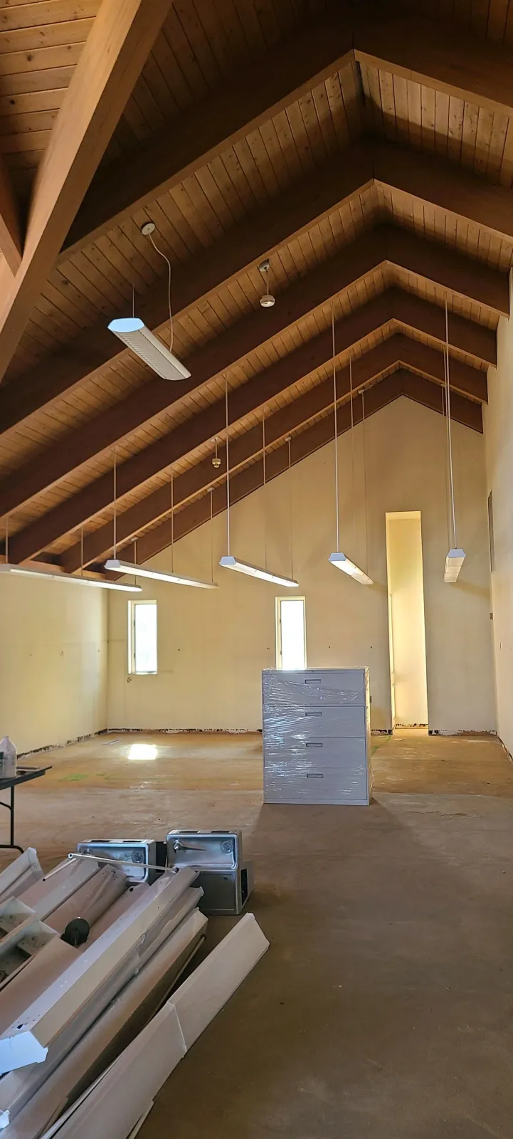 Interior of a wooden-framed attic under construction with insulation boards and lumber stacked on the floor