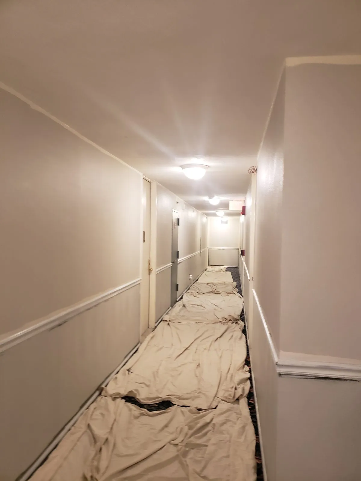 Corridor masked with drop cloths during interior painting