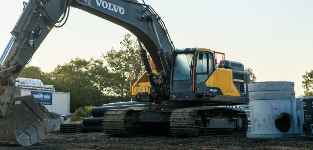 Sweeney, excavator next to concrete pipe equipment, underground-utilities-services-min