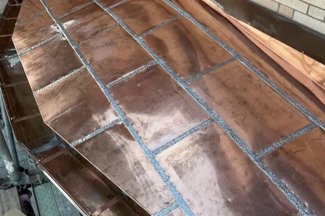 Custom fabricated copper bay roof with hand-soldered flat seam panels by Paul John & Son — architectural copper craftsmanship in Greater Boston, MA