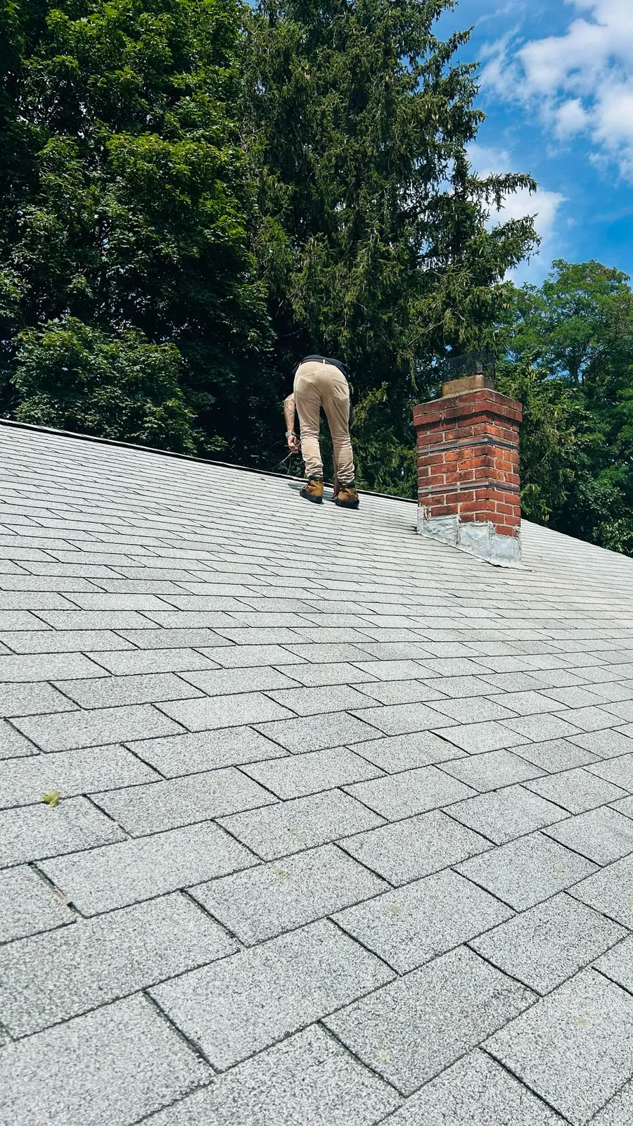 Roofer installing shingles