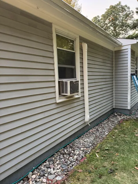 Precision installation of an exterior HVAC condenser unit on a residential property