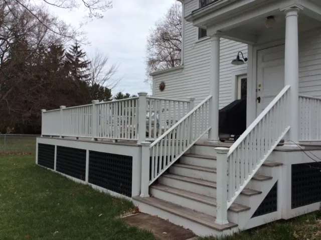 Exterior deck and stairs with white railing and lattice skirting