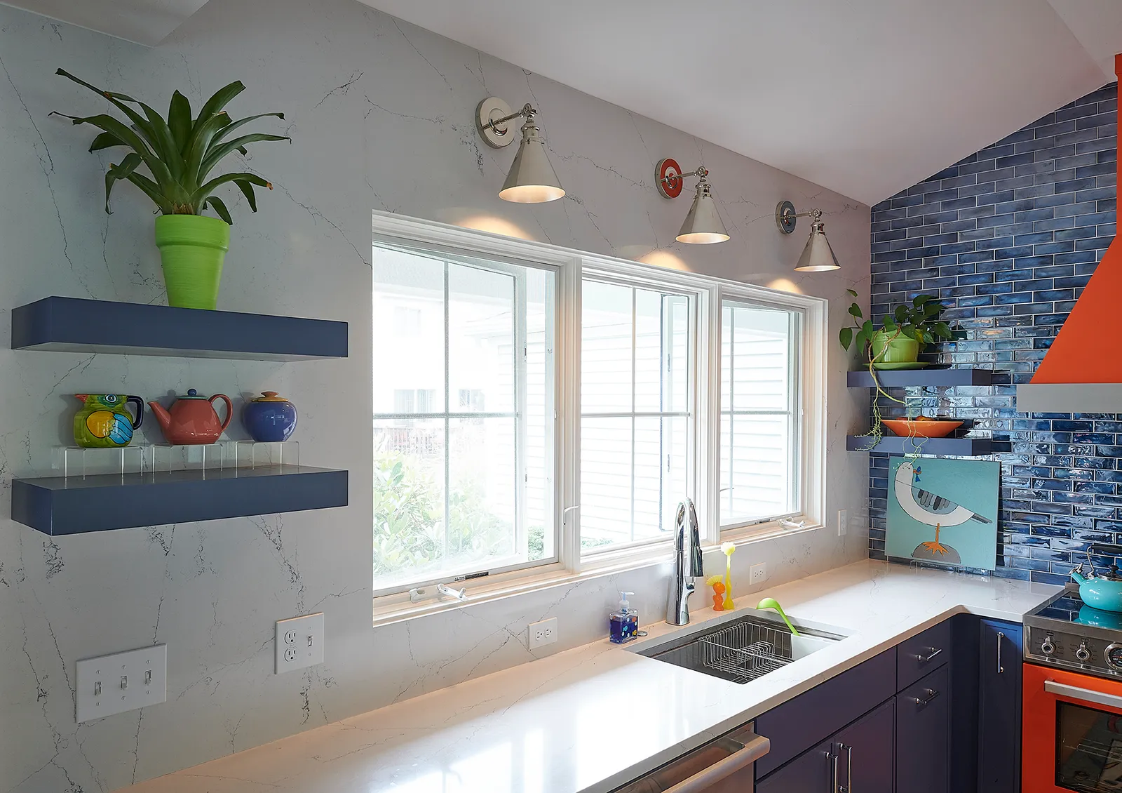 A trio of stunning windows set against a wall wrapped in flowing quartz, extending seamlessly to the countertops for an ultra-refined look.