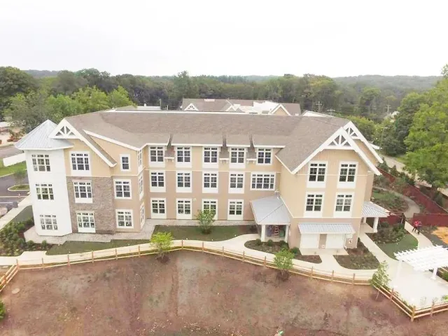 An aerial view of a large apartment building surrounded by trees.