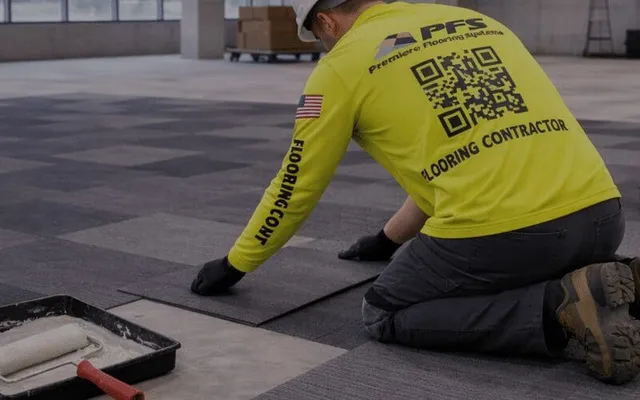 Worker installing carpet tiles in commercial space
