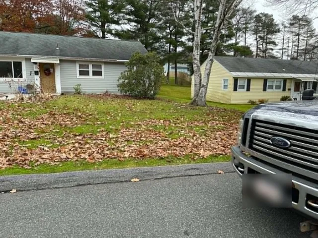 Before: fallen oak leaves covering the front lawn of a gray ranch house