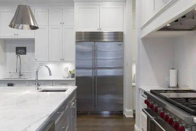 A kitchen with stainless steel appliances and white cabinets