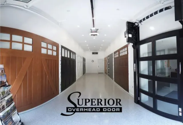Interior showroom with various garage door styles on display, including wood and glass.