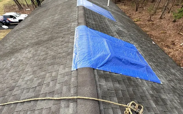 Storm-damaged roof under emergency tarps before A-Z Roofing replacement