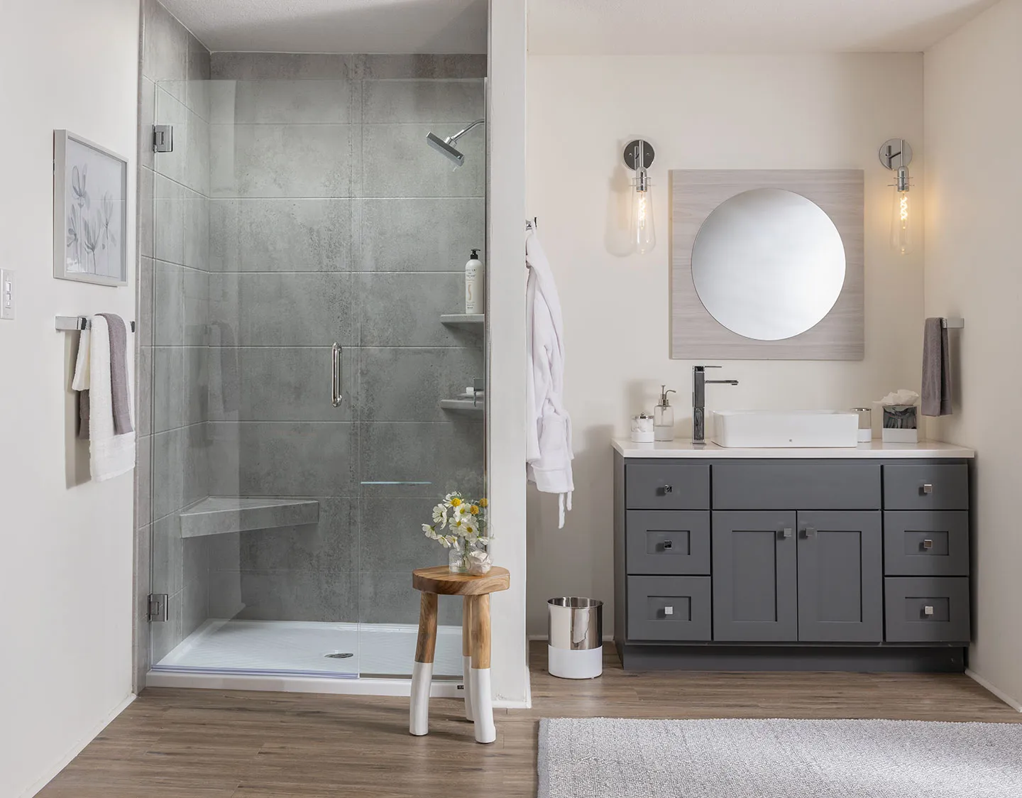 Modern bathroom remodel featuring a low-threshold white shower base with a glass enclosure and gray tile walls.