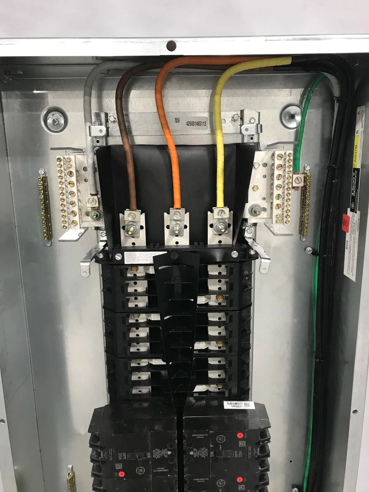 Close-up of the interior of an electrical circuit breaker panel showing various wires, breakers, and connections.