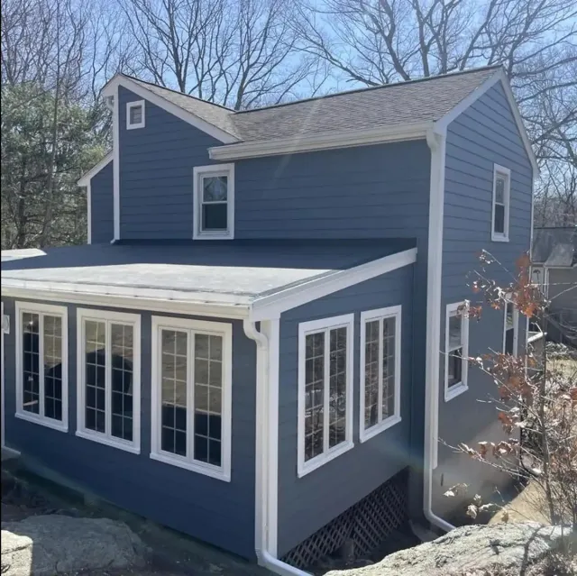 Navy lap siding and white trim on a colonial with sunroom
