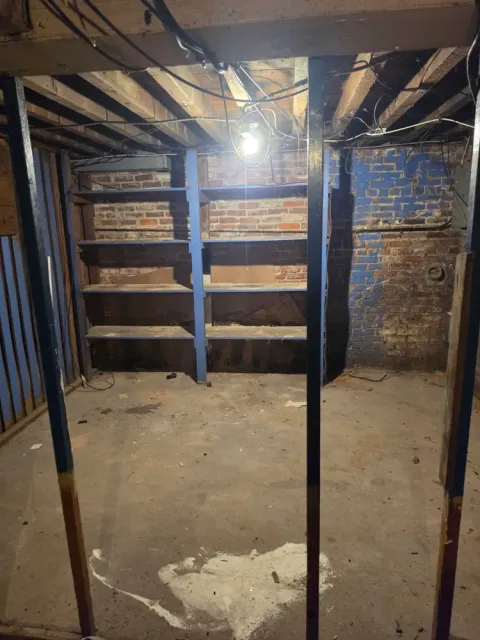 The same basement shelves and floor cleared after the cleanout
