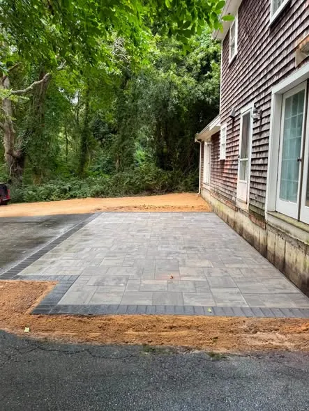 New paver patio alongside a shingled home
