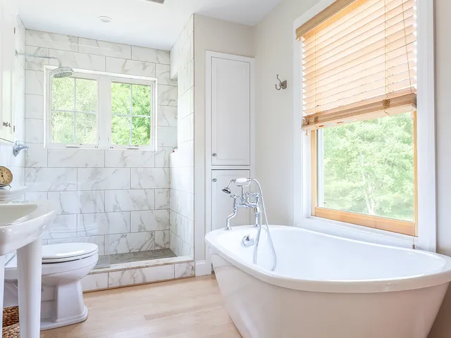 master bath with claw foot tub and wood floors