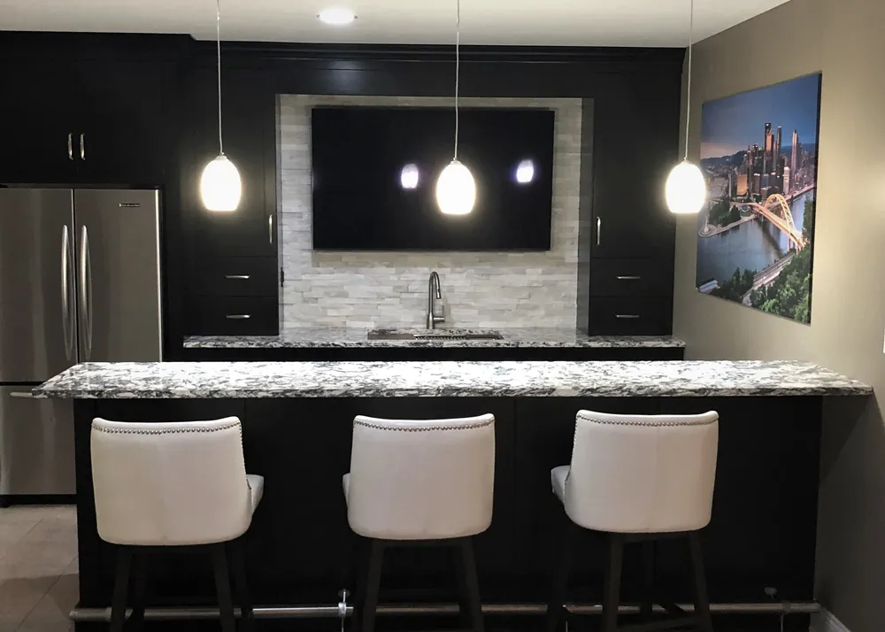 Haute Designs Kitchen & Bath. Bar. Fabuwood Cabinetry – painted Espresso. Cambria Quartz – Huntley countertop. Marble dry stack stone. Brushed nickel hardware. Full-size refrigerator. Bar foot rail