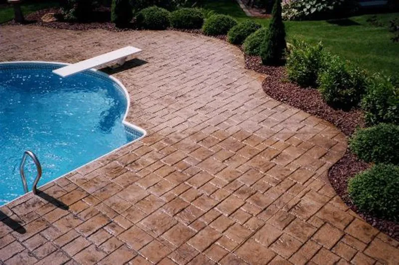 Tan brick-pattern stamped concrete pool surround