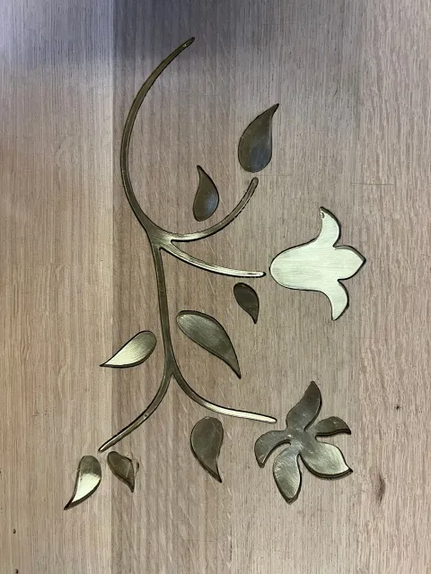Gold floral inlay on a wooden surface.