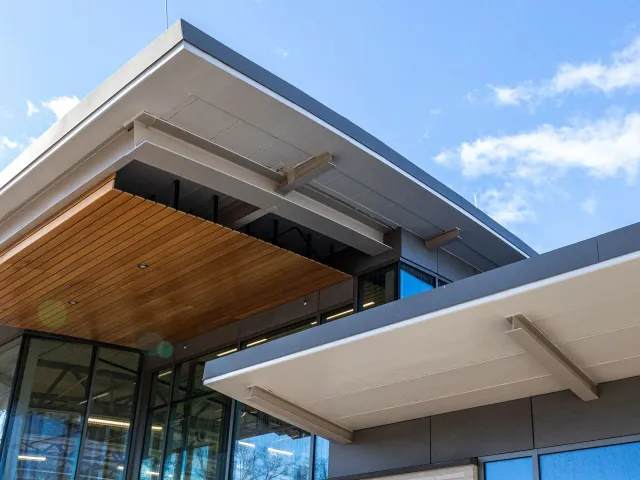 The roof of a building with a wooden ceiling and a blue sky in the background.