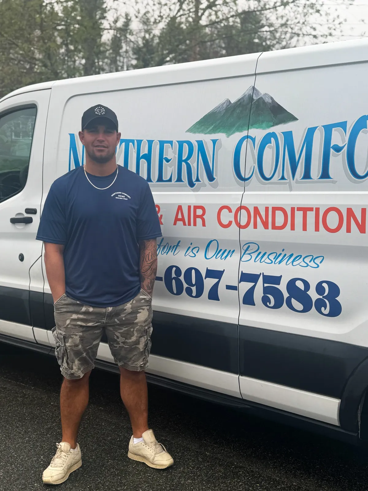 Man standing in front of a van that displays the logo and contact information for Northern Comfort Heating & Air Conditioning.