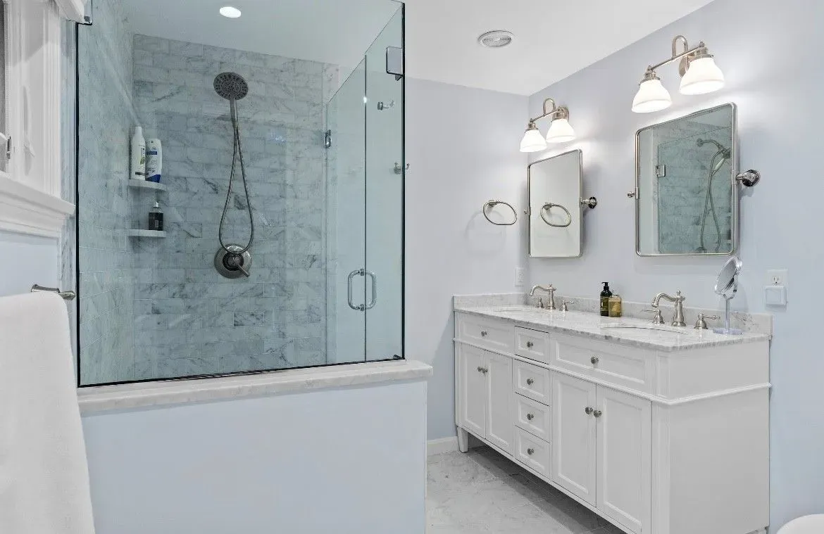 Kitchen remodel: light gray cabinets with gold hardware framing a pass-through to the dining area.