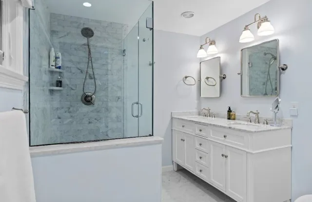 Kitchen remodel: light gray cabinets with gold hardware framing a pass-through to the dining area.