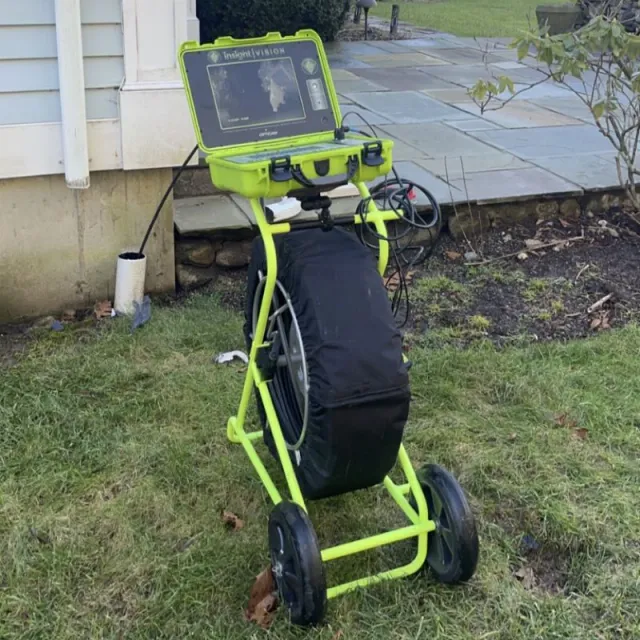Sewer camera inspection tool on wheels inspecting an outdoor drain