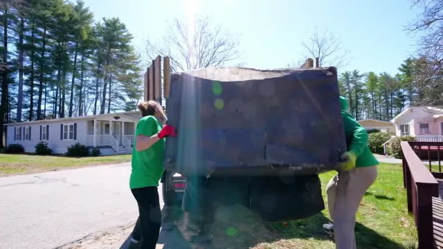Trash King crew loading a full dump trailer during a residential cleanout