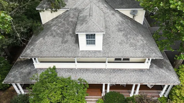Overhead view of a house with a gray shingle roof, white trim, and a small dormer window.