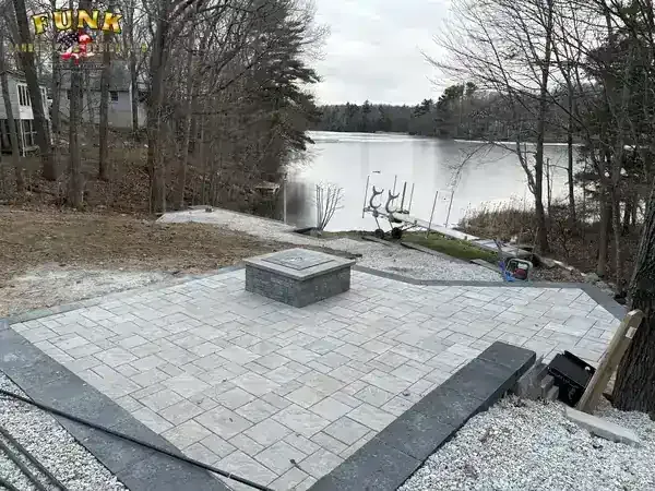 Paver patio with fire pit overlooking the lake, built by Funk Landscape & Design