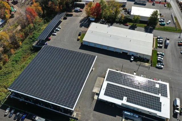 An aerial view of a building with solar panels on the roof.