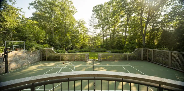 Residential sport court framed by stone walls and custom lattice screens
