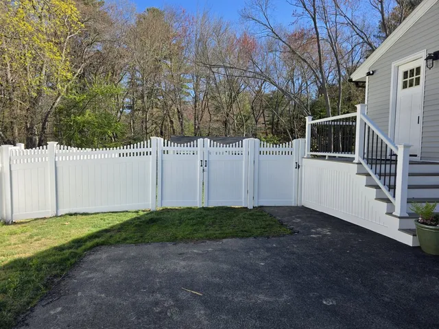 White vinyl privacy fence with scalloped picket top and gate