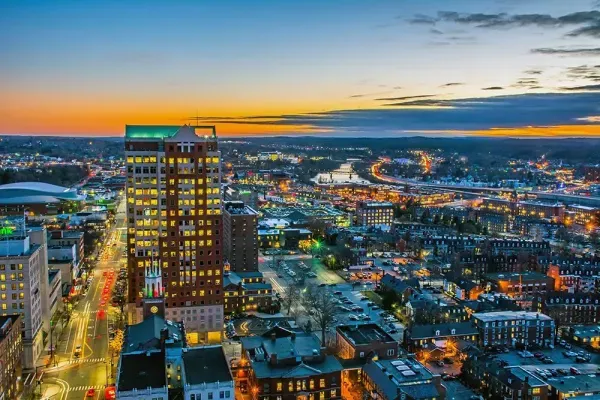 Downtown aerial skyline view of Manchester NH at dusk, served by Nault's Plumbing and Heating