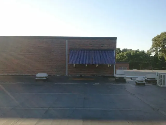 A brick building with a blue awning on the side of it