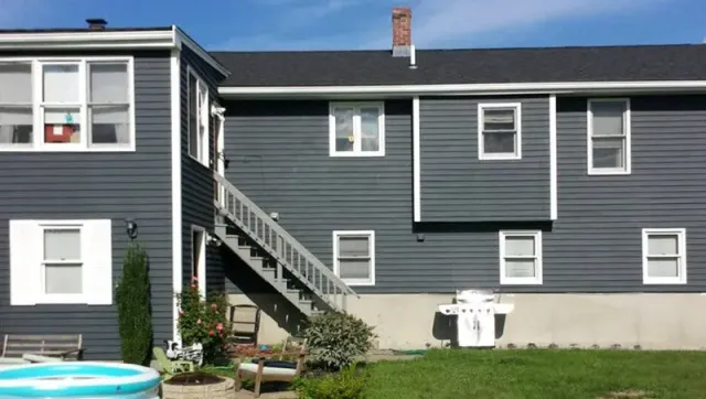 The back of a house with stairs leading up to it.